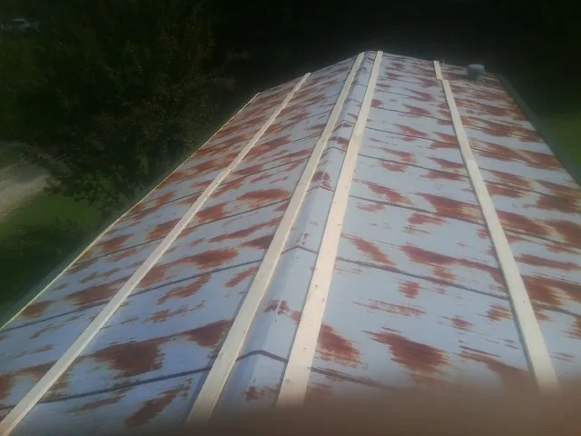 Rusted metal roof panels with new wood purlins before replacement — Storm Damage Roof Repair in Castalian Springs by Roofing Brothers