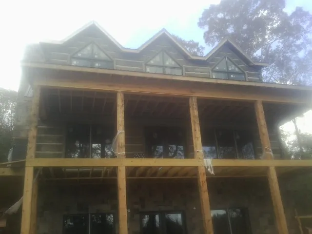 Dormers and porch framing on a large log home under construction — Roof Coating work by our crew in Castalian Springs