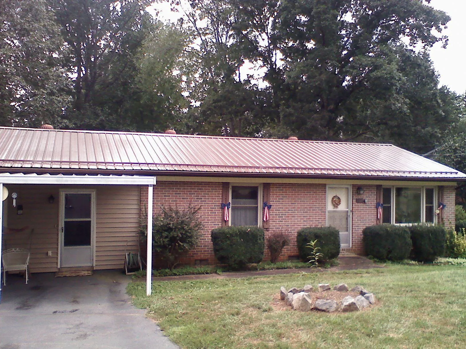 Bronze metal roof and carport on a brick ranch home — Roof Repair work by our crew in Castalian Springs